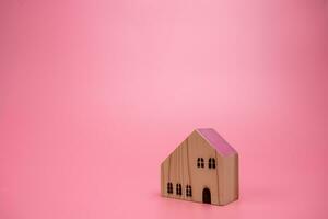 Holz Haus Modell- auf Rosa Hintergrund , Verwaltung Eigentum Investition Konzept, Banner Hintergrund foto