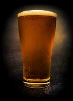 Glas von Bier auf dunkel Hintergrund, Licht Bier im ein Glas, zugfrisch Licht Bier.Nahaufnahme. foto