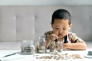 Vorschulkind Kind Lernen zu Berechnung persönlich Budget, verwalten Finanzen, spielen Investition, Buchhaltung. konzentriert Schule Kind Speichern Geld zum kaufen, Putten Kasse im Rosa Schweinchen Bank beim heim. foto