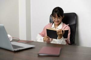 Schule Alter Schüler tun ihr Hausaufgaben mit Digital Tablette beim heim, Kind mit Gadgets zu Studie Bildung und Entfernung Lernen zum Schule zu Hause Kinder während Quarantäne beim Zuhause Unterhaltung. foto