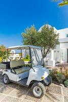 Weiß Golf Auto mit zurück Sitz auf Resort Rezeption, Auffahrt. Luxus Hotel oder Golf Verein Vertikale Hintergrund. Luxus Sommer- Szene mit elegant Weiß die Architektur. foto