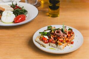 Vorspeise Bruschetta gekrönt mit Tomaten wild Rakete Blätter und Anschovis. foto