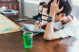 Schule Junge mit Stift Stift Schreiben auf Digital Notizblock. foto