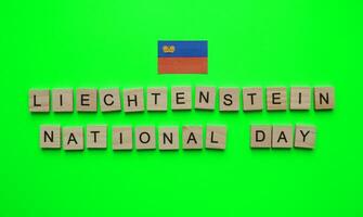 August 15, Liechtenstein Unabhängigkeit Tag, Liechtenstein National Tag, Liechtenstein Flagge, minimalistisch Banner mit das Inschrift im hölzern Briefe auf ein Grün Hintergrund foto