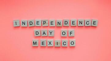 September 16, Unabhängigkeit Tag von Mexiko, Flagge von Mexiko, minimalistisch Banner mit das Inschrift im hölzern Briefe auf ein Rosa Hintergrund foto