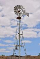 ein Windmühle auf ein Wüste einfach mit ein wolkig Himmel foto