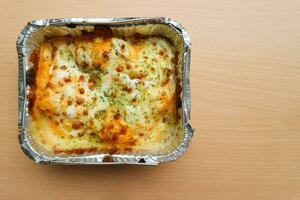 Pasta makaroni saus keju oder Pasta Mac und Käse im das Aluminium vereiteln Schüssel auf das hölzern Hintergrund foto