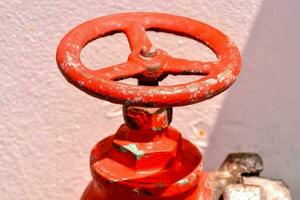 ein rot Feuer Hydrant mit ein Weiß Mauer foto