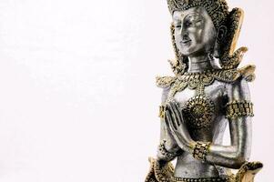 ein Statue von ein thailändisch Göttin auf ein Weiß Hintergrund foto