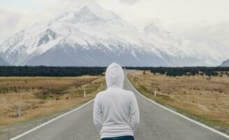 Frauen Stehen auf das Straße zu aoraki montieren Koch das höchste Berge im Neu Neuseeland. foto