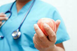 asiatisch Ernährungsberater halten Apfel gesund Essen zum geduldig im Krankenhaus, Ernährung und Vitamin. foto