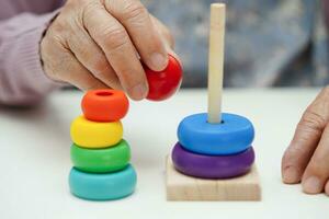 asiatisch Alten Frau spielen Rätsel Spiel zu trainieren Gehirn Ausbildung zum Demenz Verhütung, Alzheimer Krankheit. foto