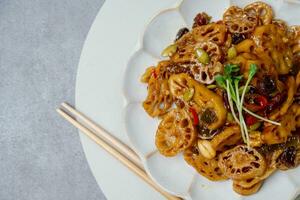 Koreanisch Essen yeongeunjorim, geschmort Lotus Wurzeln, yeongeun parboiled und geschmort im ein Mischung von Soja Soße und Zucker Über niedriger Hitze. hinzufügen Sirup und schmoren zu ein Glasur Vor Portion. foto