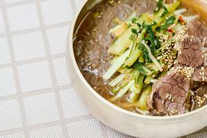 yeolmunaengmyeon, Koreanisch Stil Buchweizen Nudeln mit junger Sommer Rettich Kimchi, diese Gericht Eigenschaften kalt Nudeln im Kimchi Suppe Das ist gemacht durch Mischen gesalzen jung Rettich foto