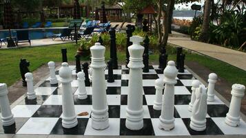 groß Schach auf Riese Schachbrett im Park außen. foto