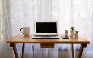 Schreibtisch mit Computer, Kaffeetasse, Smartphone im Wohnzimmer foto