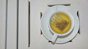 gesund Kamille Tee ist gegossen in ein Weiß Tasse foto