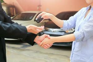 Geschäft Hand geben ein Schlüssel von Käufer beim Vermietung Wagen. foto