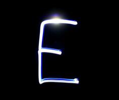 e einfach Alphabet Hand Schreiben Blau Licht Über schwarz Hintergrund. foto