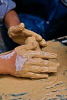 das Hände von ein Kind Wer ist tun Aktivitäten zu machen Kunsthandwerk von Lehm oder häufig namens ein Keramik Klasse und etwas von das Ergebnisse foto