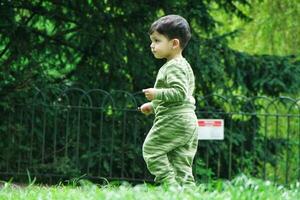 süß asiatisch pakistanisch Baby ist genießen das schön sonnig Tag beim Krieg Kinder und Öffentlichkeit Park von Luton Stadt, Dorf von England Vereinigtes Königreich. niedrig Winkel Bild war gefangen auf April 03., 2023 foto