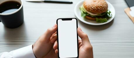 unbekannt Fachmann mit leer Bildschirm Handy, Mobiltelefon Essen während Arbeiten foto