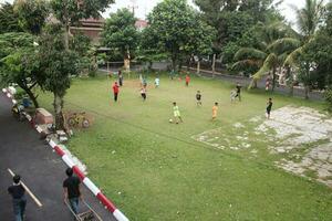 bogor - - Indonesien, August 12, 2023, wenig Kinder spielen Fußball auf das Feld foto