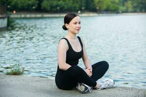 jung Frau im schwarz Sportbekleidung ausüben draußen. Fitness und gesund Lebensstil Konzept. das Weiß Mädchen tut Sport im das Park. foto