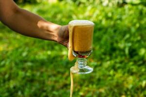 weiblich Hand hält ein Glas mit Weiß Kwas, Sanft Getränke foto