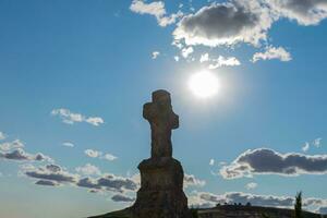 katholisch Granit Kreuz mit Blau Himmel und beleuchtet Sonne foto