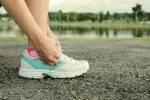 Frauen binden Sport Schuh bereiten Joggen beim Park. foto