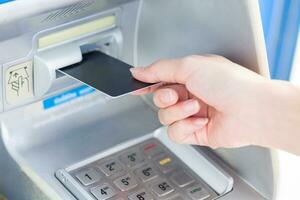 schließen oben Hand Einfügen Karte in Geldautomat. foto