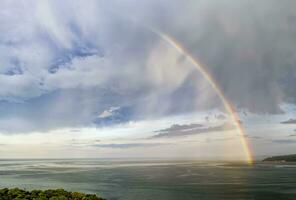 atemberaubend groß Regenbogen nach das Regen Über das Meer foto