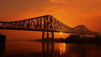 Sonnenaufgang Silhouette von Howra Brücke ein suspendiert Spanne Über das höhnisch Fluss im Westen Bengalen foto