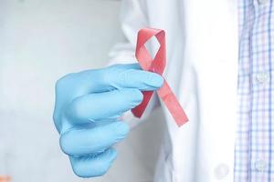 Arzthand hält rosafarbenes HIV-Band Nahaufnahme foto