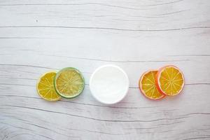 Draufsicht auf Vaseline in einem Behälter und Zitronenscheibe auf dem Tisch