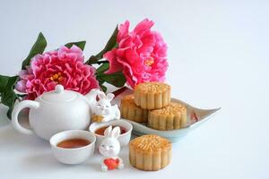 Chinesisch mitte Herbst Festival Konzept gemacht von Mondkuchen, Tee dekoriert mit Pflaume blühen und Kaninchen isoliert auf Weiß Hintergrund. foto