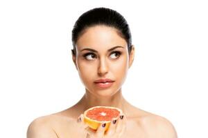 gesund Essen Konzept. schön jung Frau halten Stück von Grapefruit, isoliert Über Weiß Hintergrund foto