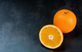 Orangenfrucht auf dem Tisch mit schwarzem Hintergrund foto