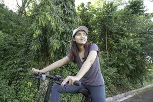 indonesisch Frau Radfahren um das Park im das Morgen. foto