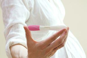 ein schwanger Frau halten ein Rosa Zahnbürste foto
