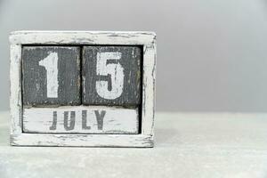 Kalender zum Juli 15, gemacht von hölzern Würfel, auf grau hintergrund.mit ein leeren Raum zum Ihre Text. foto