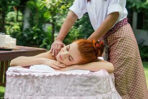 jung schön Frau entspannend im Spa Massage draußen im tropisch Garten. foto