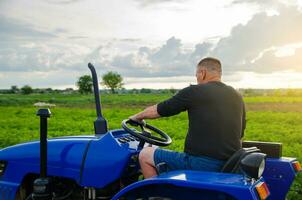 Farmer fährt ein Traktor. Ernte Pflanzen Kampagne, Erdarbeiten. Agro-Industrie und Landwirtschaft. Landschaft Ackerland. Landwirtschaft. landwirtschaftlich Maschinen Management. foto