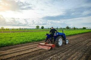 ein Mann Farmer funktioniert im ein Bauernhof Feld. kultivieren das Boden Vor Pflanzen ein Neu Ernte. Mahlen, Quetschen und Lockerung Boden. Landwirtschaft. Landwirtschaft Landwirtschaft. Rekrutierung Arbeitskräfte mit Fahren Kompetenzen foto