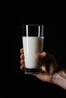 Hand halten ein Glas von frisch Milch isoliert auf schwarz Hintergrund. ai generiert foto