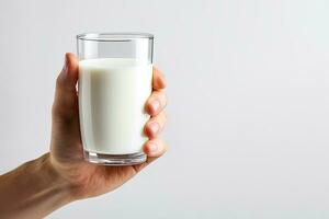 Hand halten ein Glas von frisch Milch isoliert auf grau Hintergrund mit Kopieren Raum. ai generiert foto