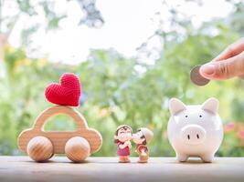 Schweinchen Bank, hölzern Spielzeug Auto und schön Paar. das Konzept von Speichern zum Auto von Familie. foto