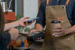 frau verwendet smartphone, um qr-code zu scannen, um im caférestaurant mit einer digitalen zahlung ohne bargeld zu bezahlen. Menü wählen und bestellen Rabatt kumulieren. E-Geldbörse, Technologie, online bezahlen, Kreditkarte, Bank-App. foto