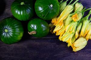 Kofferraum Zucchini und Blumen auf rustikal Holz foto